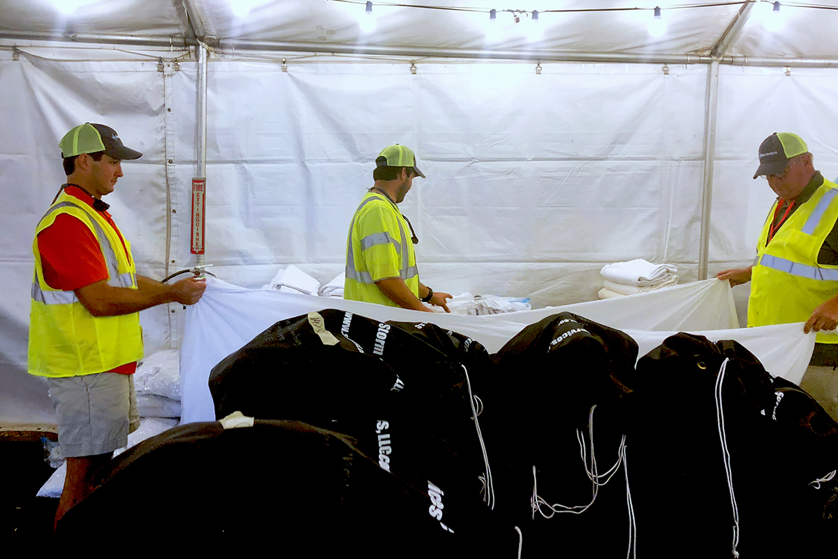 Team Members folding and storing laundry for camp residents.